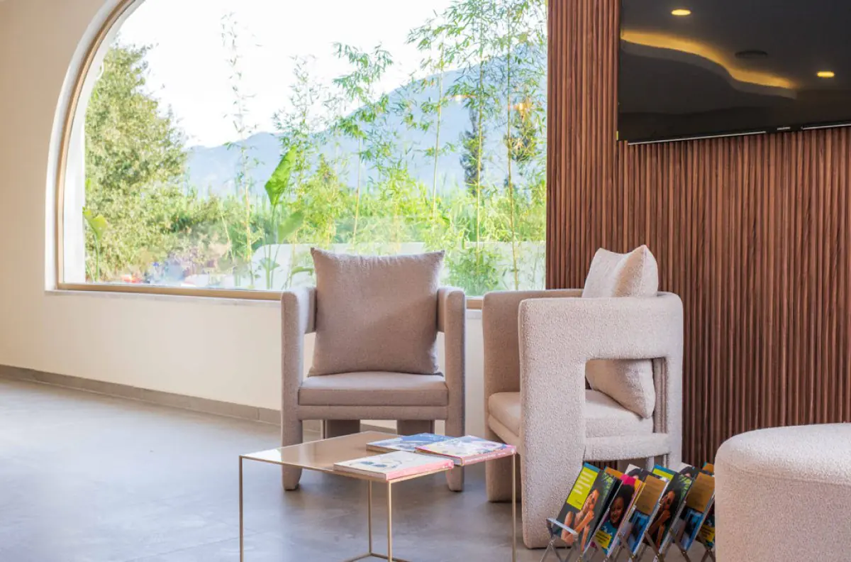 Espace d'attente moderne à D’Art Dental Clinic avec fauteuils et grande fenêtre