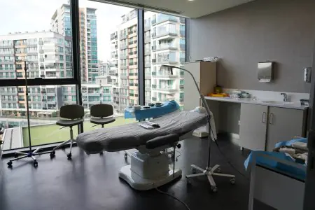 Sala de tratamiento moderna en Bank of Hair con vista a la ciudad, equipada para trasplante capilar