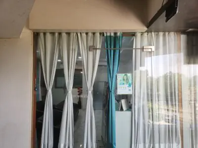مدخل ومنطقة استقبال في عيادة Burute Dental Clinic بأبواب زجاجية وستائر