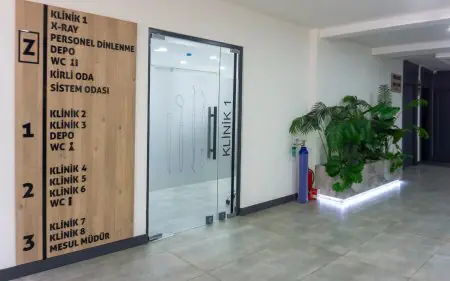 ممر عيادة أسنان حديث في MRV Dental مع دليل العيادة وباب زجاجي