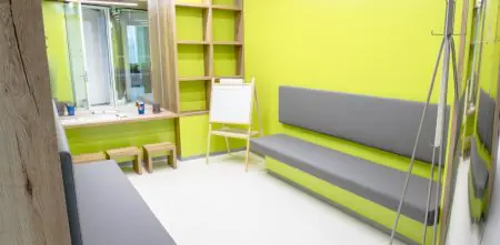 غرفة انتظار MY CLINIC بمقاعد حديثة وجدران صفراء زاهية