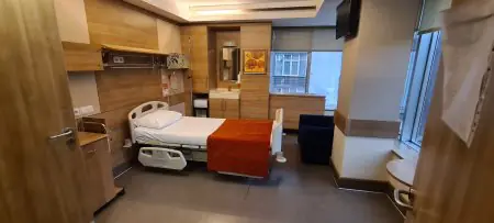 غرفة مريض في عيادة MEDICTERREAN® بسرير حديث وديكور خشبي