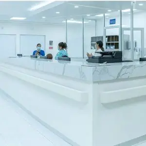 Mostrador de recepción en CeMar Surgery con personal en clínica moderna