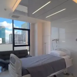Habitación de paciente en CeMar Surgery con cama hospitalaria y vista a la ciudad