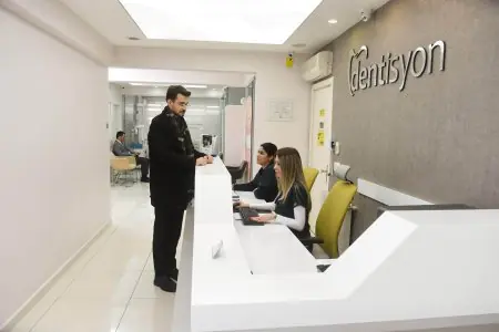 منطقة الاستقبال في عيادة Dentisyon لطب الأسنان مع طاقم يساعد المرضى