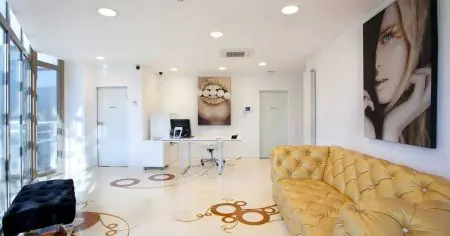 Recepción en Dr. Vlădău Studio con decoración moderna y sofá amarillo