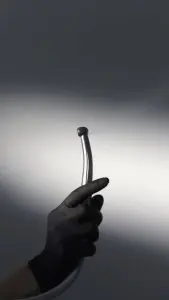 قبضة جهاز حفر الأسنان في Axilar Dental Clinic ممسوكة بيد مرتدية قفاز