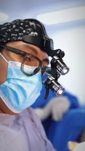 جراح يستخدم عدسات مكبرة في غرفة العمليات عيادة Dr. Lucio A. Santos Moyrón