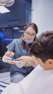 طبيب أسنان يعلّم طفلًا نظافة الفم في Marinadiş Oral and Dental Clinic