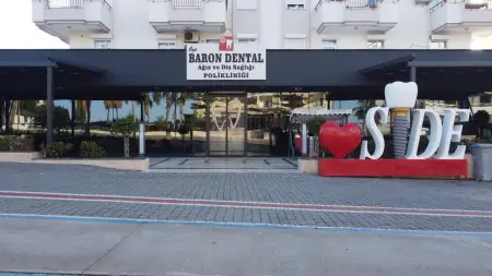 واجهة Baron Dental Clinic في سايد، تركيا مع تمثال زرع الأسنان