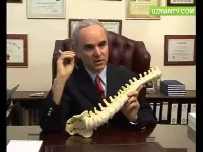 Médico en Doç. Dr. Ahmet Yıldızhan Muayenehanesi explica modelo de columna en oficina