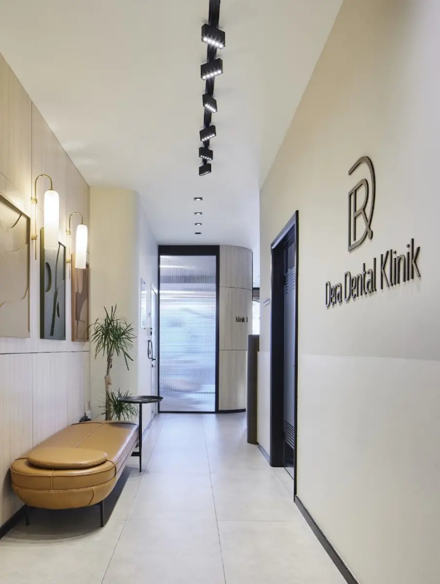 Nowoczesny korytarz recepcji w Dera Dental Clinic z miejscem do siedzenia i logo kliniki