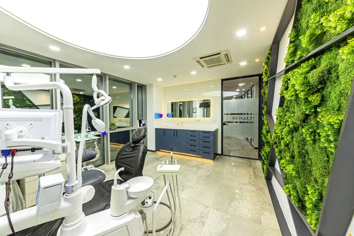 Moderner Behandlungsraum bei 360 Dental Clinic mit grüner Wand und moderner Ausstattung