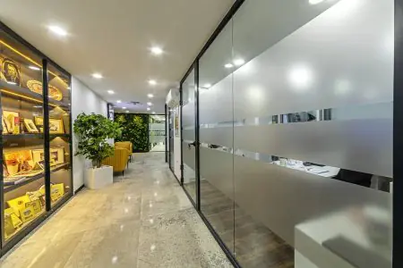 Pasillo moderno con divisores de vidrio en 360 Dental Clinic