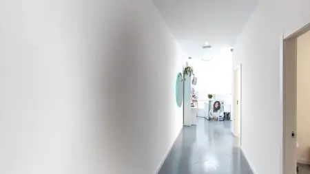 Pasillo luminoso hacia la recepción de Derma Clinic Spain, interior médico moderno