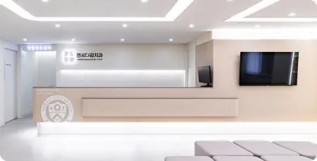 Área de recepción en Yonsei Dagam Dental, diseño moderno con TV y asientos