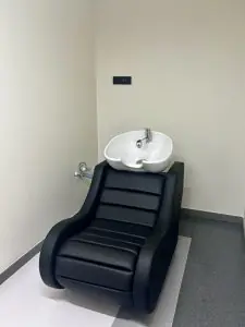 Estación de lavado de cabello en DALI HAIR CLINIC con silla negra moderna