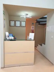 مكتب استقبال في عيادة GNUX Dental مع شهادات معلقة على الجدار