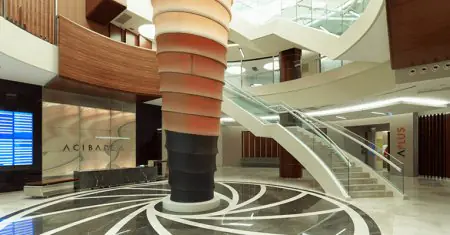 منطقة استقبال حديثة في عيادة Acibadem في تركيا مع درج حلزوني وديكور أنيق