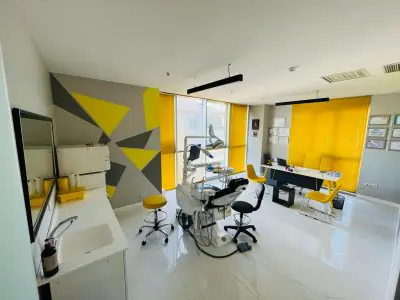 غرفة علاج أسنان حديثة في KidsDent Istanbul مع لمسات صفراء ومعدات