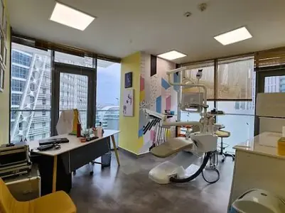 غرفة علاج أسنان حديثة في KidsDent Istanbul مع إطلالة على المدينة وكرسي أسنان