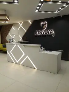 مكتب استقبال في عيادة أداليا لطب الأسنان بتصميم حديث مضاء