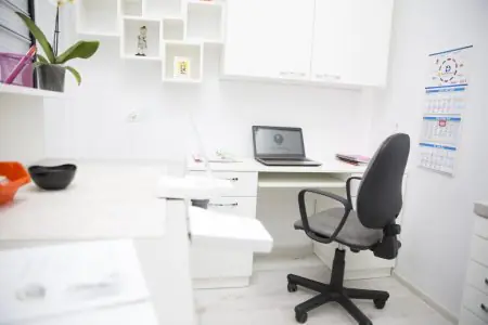 مكتب الطبيب في عيادة AllDental مع مكتب حديث وجهاز لابتوب