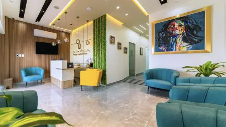 Recepción de la clínica DR. JUNEN GOMEZ DIAZ con asientos modernos y arte