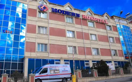 واجهة عيادة Modern Hospital مع سيارة إسعاف أمام المدخل