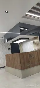 Mostrador de recepción en la clínica Mesta Dent con diseño moderno de madera y mármol