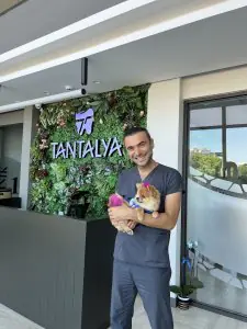 منطقة الاستقبال في عيادة Tantalya لطب الأسنان مع موظف وجدار نباتات خضراء