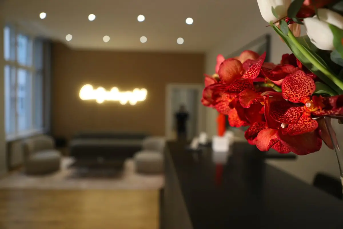 Área de recepción en SA Aesthetics Berlin con sala moderna y decoración floral