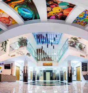 Amplia recepción en Miracle IVF Cyprus con decoración moderna y techo colorido