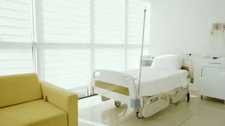 غرفة مريض في عيادة Med Pearl Group بسرير مستشفى وأثاث حديث