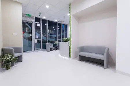 منطقة انتظار حديثة في Medi Horizon Clinic مع أرائك رمادية وديكور زهور