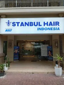 Entrada de la clínica Istanbul Hair Indonesia con puertas de vidrio y letrero