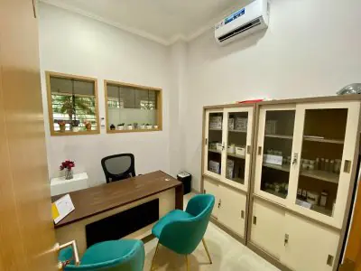 Sala de consultas en la clínica Istanbul Hair Indonesia con escritorio y armarios médicos