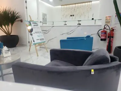 Área de recepción en Paradise Polyclinic con asientos modernos y decoración de mármol