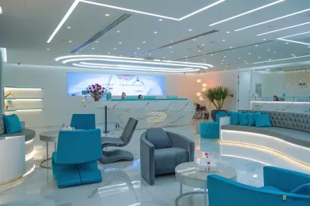 Recepción y sala de espera moderna en Paradise Polyclinic con asientos azules