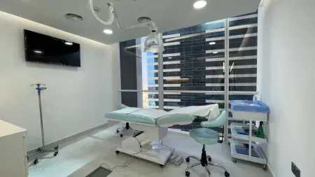 Sala de tratamiento moderna en Paradise Polyclinic con equipo médico y vista a la ciudad