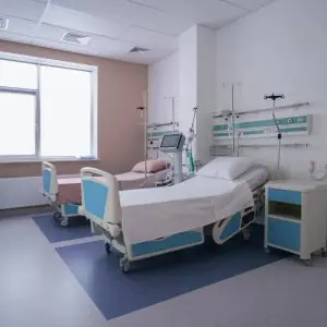 غرفة مرضى بسريرين حديثين ومعدات طبية في I.D. Clinic