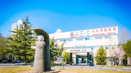 واجهة مستشفى OASIS الدولي مع المدخل الرئيسي وتمثال، بكين