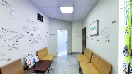 غرفة انتظار في مركز MML الطبي وارسو بمقاعد صفراء وجدران موقعة