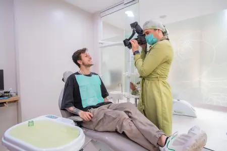 غرفة استشارة طب الأسنان في Dentica by Cristina Suaza مع مريض وطاقم العمل