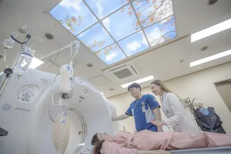 Sala de tomografía en Myongji Hospital con equipo moderno y personal médico