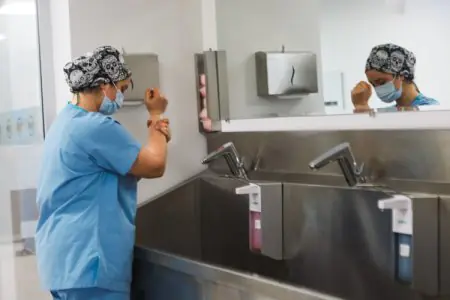 الطاقم الطبي يغسل يديه في منطقة التعقيم بمركز Vanity Cosmetic Surgery Center