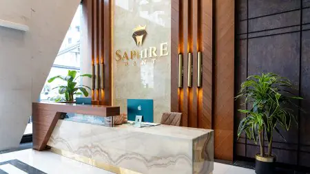 Área de recepción en SaphireDent Dental Clinic con decoración moderna y ordenadores