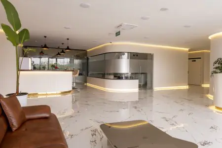 منطقة الاستقبال في عيادة DRA Dental Clinic بأرضية رخامية حديثة وصالة انتظار