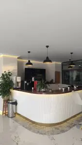 منطقة الاستقبال في عيادة DRA Dental Clinic بتصميم حديث ومحطة قهوة