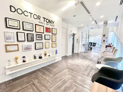 Área de recepción de Doctor Tony Clinic con premios y asientos modernos